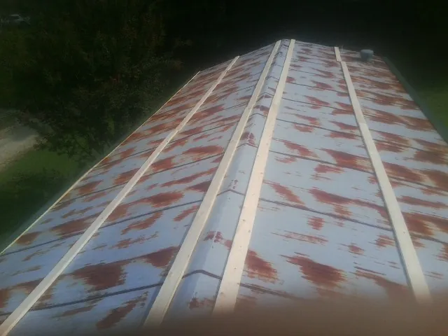 Rusted metal roof panels with new wood purlins before replacement — Storm Damage Roof Repair in Elm Mott by Roofing Brothers