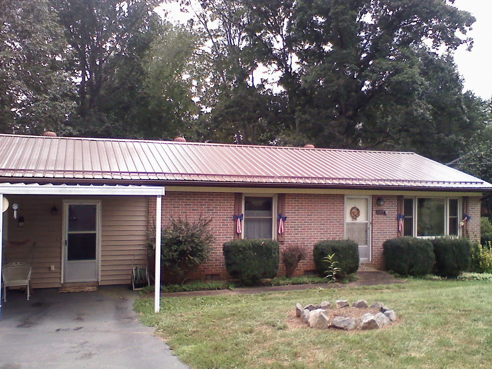 Bronze metal roof and carport on a brick ranch home — Roof Repair work by our crew in Elm Mott